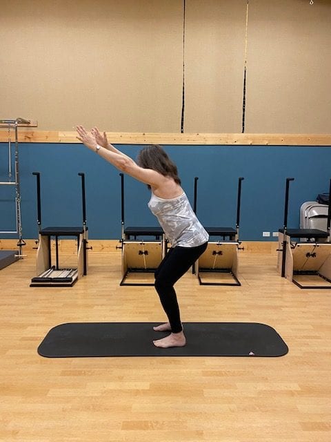 Debbie B performing standing pilates pose