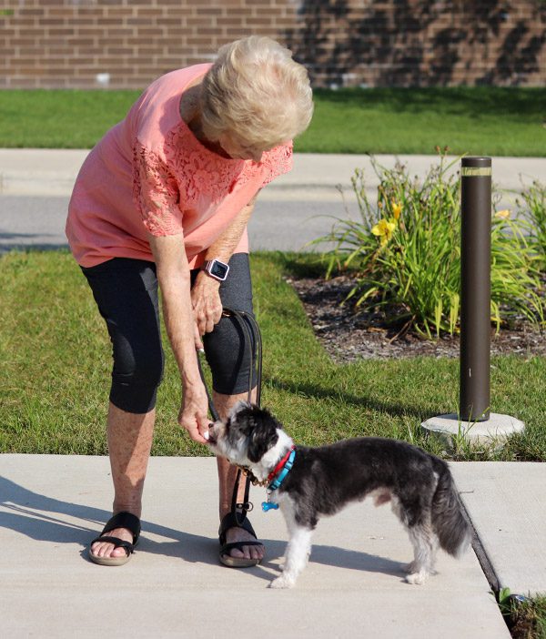 Doris gives her dog a treat.