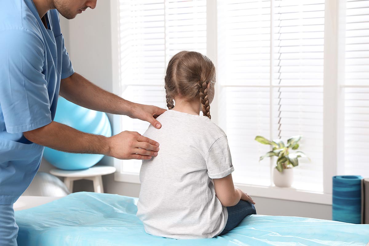 Young girl at the doctor, checking for scoliosis