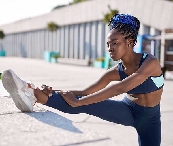 young woman performing the standing hamstring stretch