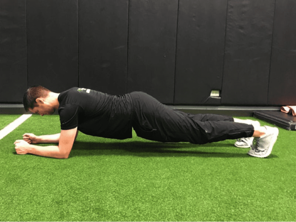 a man doing a plank with his back positioned in a low arch