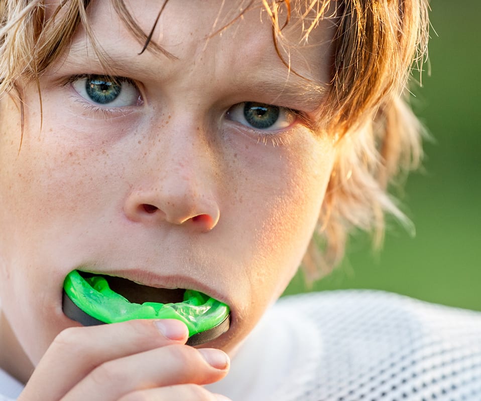Young Athlete Putting in his Mouthguard