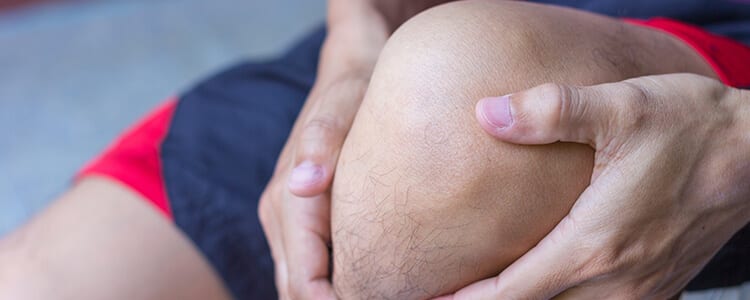 man holding knee in pain
