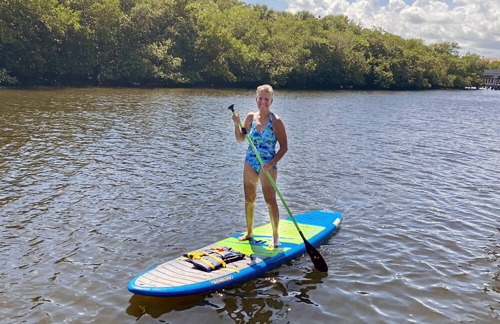 Kim, an IBJI rotator cuff surgery patient, paddle boards after recovering from her procedure