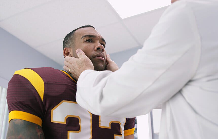 Football player being checked for concussion