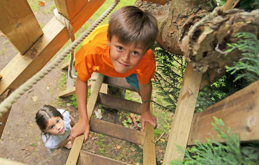 kids climbing up a treehouse.